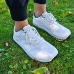 White barefoot sneakers worn outdoors on grass