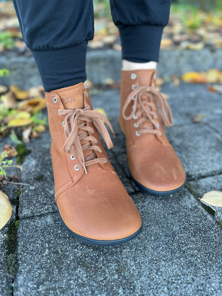 Brown leather barefoot lace-up boots paired with casual pants.