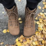 Brown barefoot boots standing on yellow autumn leaves.