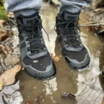 Black waterproof barefoot boots tested in a large muddy puddle.
