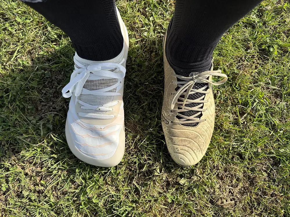 Barefoot soccer cleat on the left compared with a traditional narrow football cleat on the right.