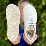 Person holding barefoot sneaker to show sole pattern