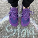 Purple barefoot sneakers worn outdoors on pavement